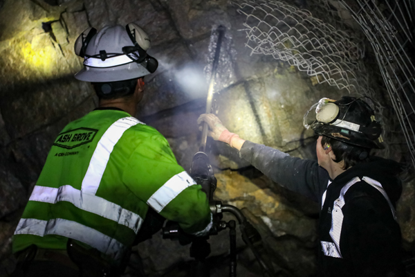 Two students drilling in an underground mine