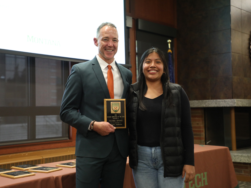 A man and a woman posing with a plaque