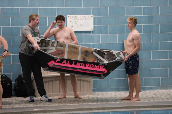 Students carry a cardboard boat