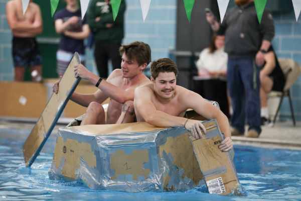 Students paddle a cardboard boat