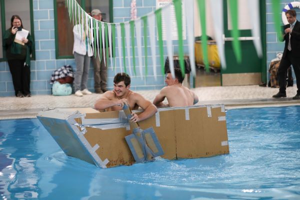 Students paddle a cardboard boat