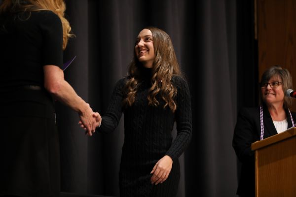 A nursing student shakes the hand of Director of Nursing Janet Coe on stage