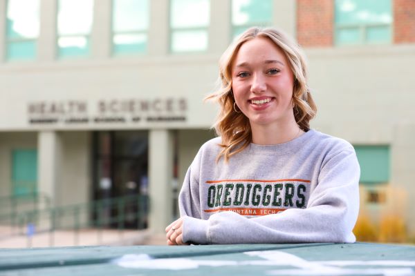 !Taylor McKinley-Whitcomb poses for a photo in front of the Health Sciences building