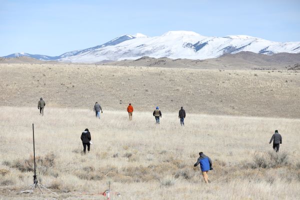 Students search for their model rocket.