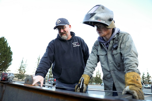 !Instructor Jim LeProwse works with a welding student