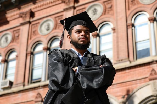 Umaer Zaki poses for a photo in cap and gown