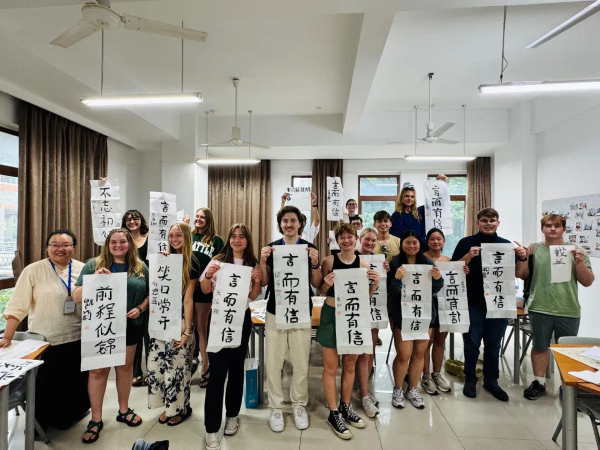 Students pose with calligraphy.