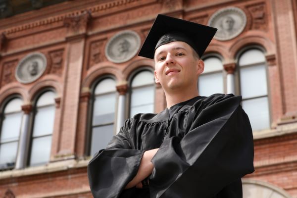 Nathan Ostwald poses in cap and gown