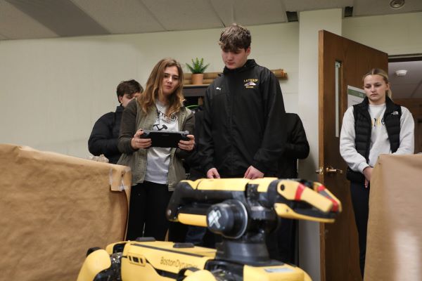 !Four students work with SPOT, a mining robot