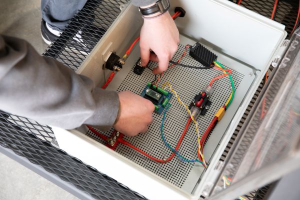 Students work on the electrical components of the solar-powered composter.