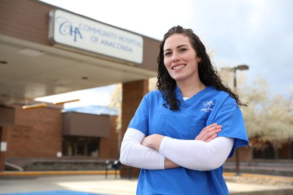 !Chloe Jones in scrubs in front of Community Hospital of Anaconda