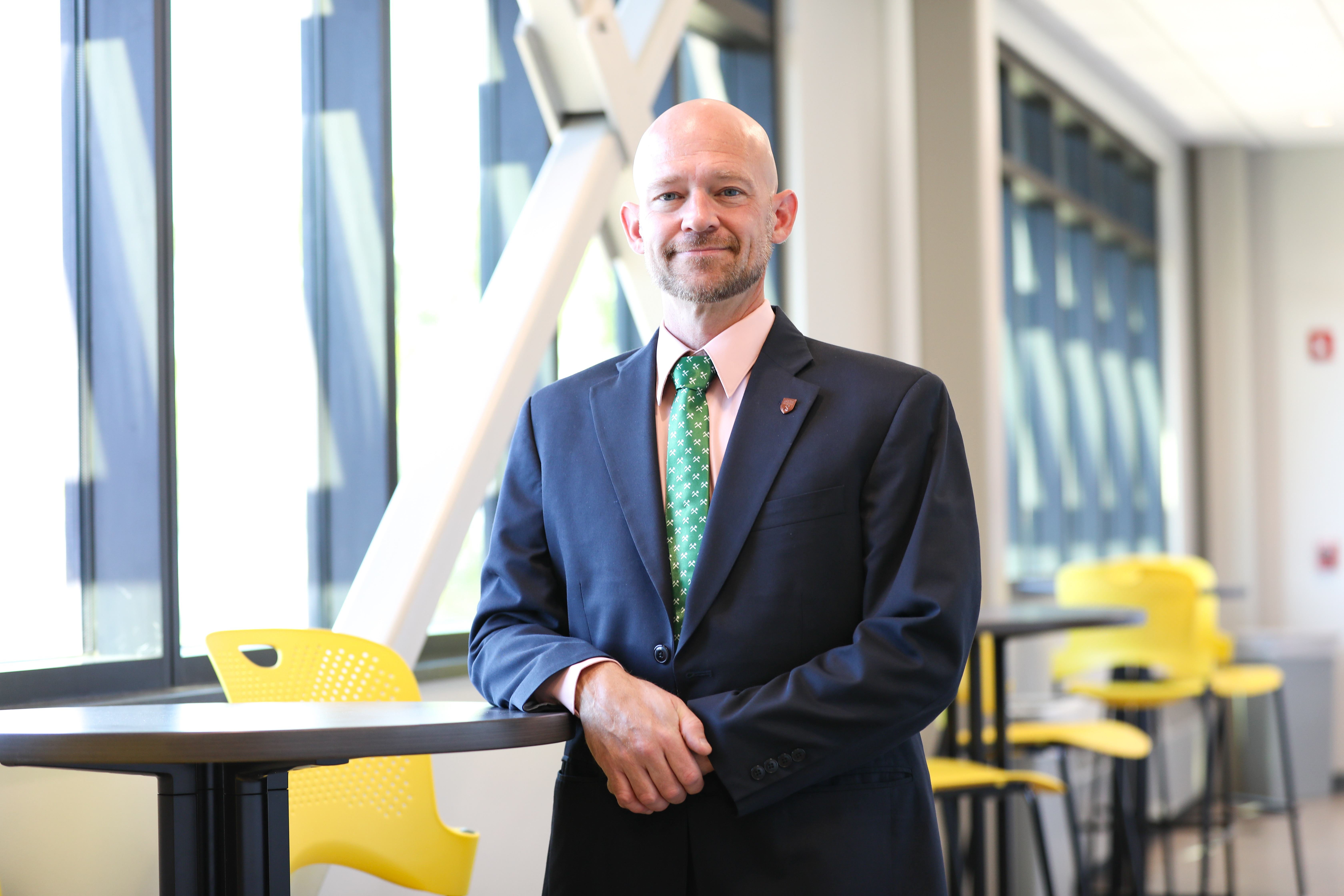 !Portrait of Dr. Matthew standing in a building on campus