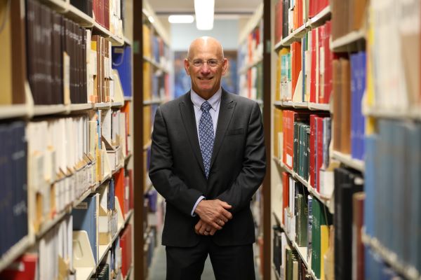 !Bob Morris stands in between book stacks in Montana Tech's library