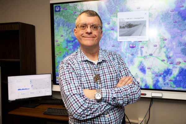 !Doug Galarus in front of smartboard with OSS website behind him