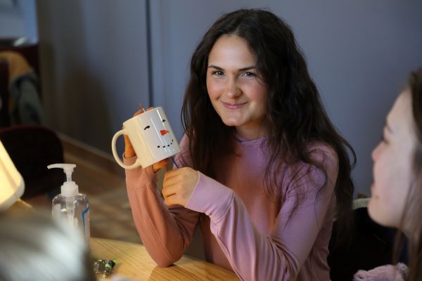 A student with a mug painted like a snowman