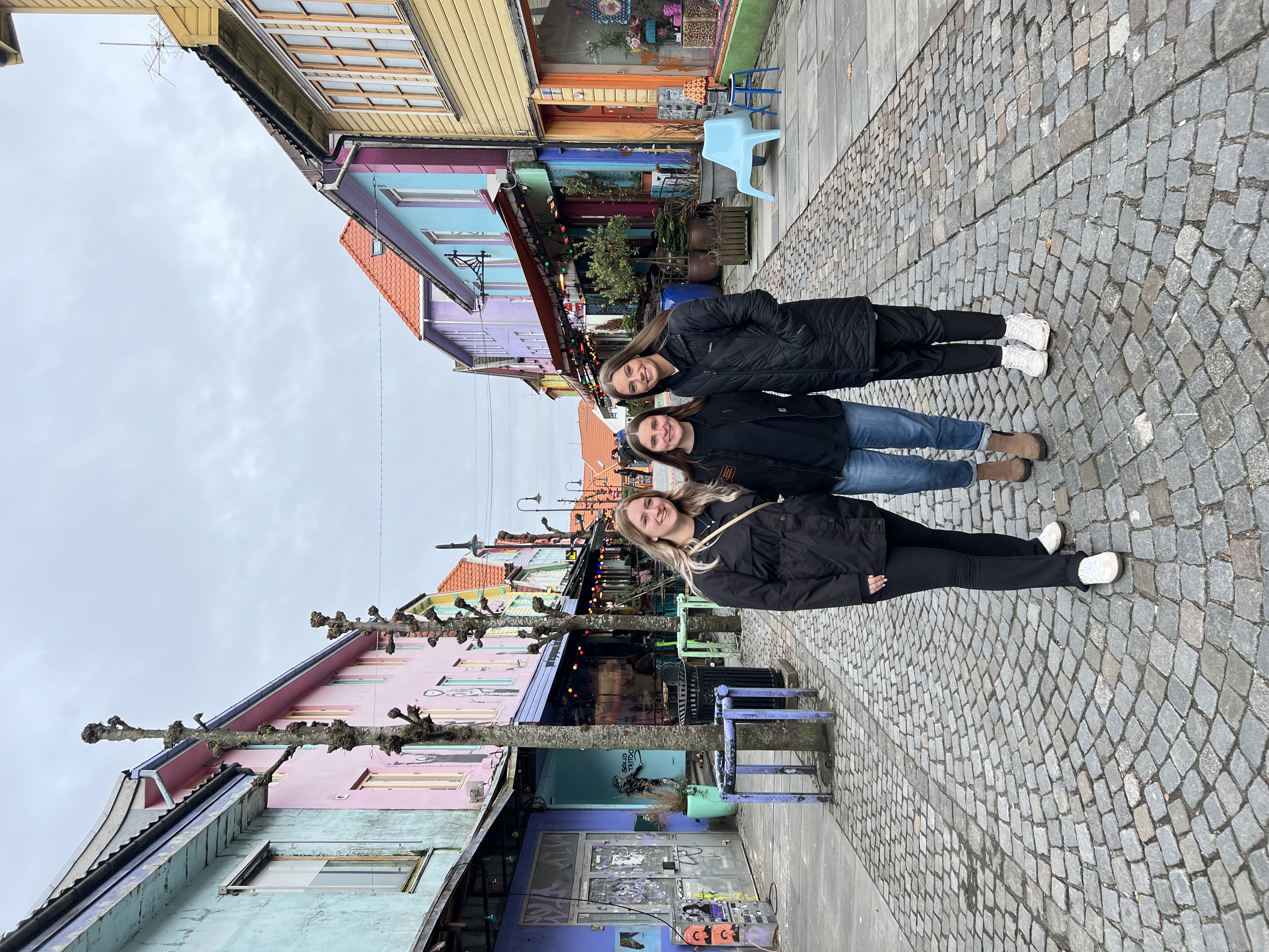 Three students pose for a photo on Colorful Street