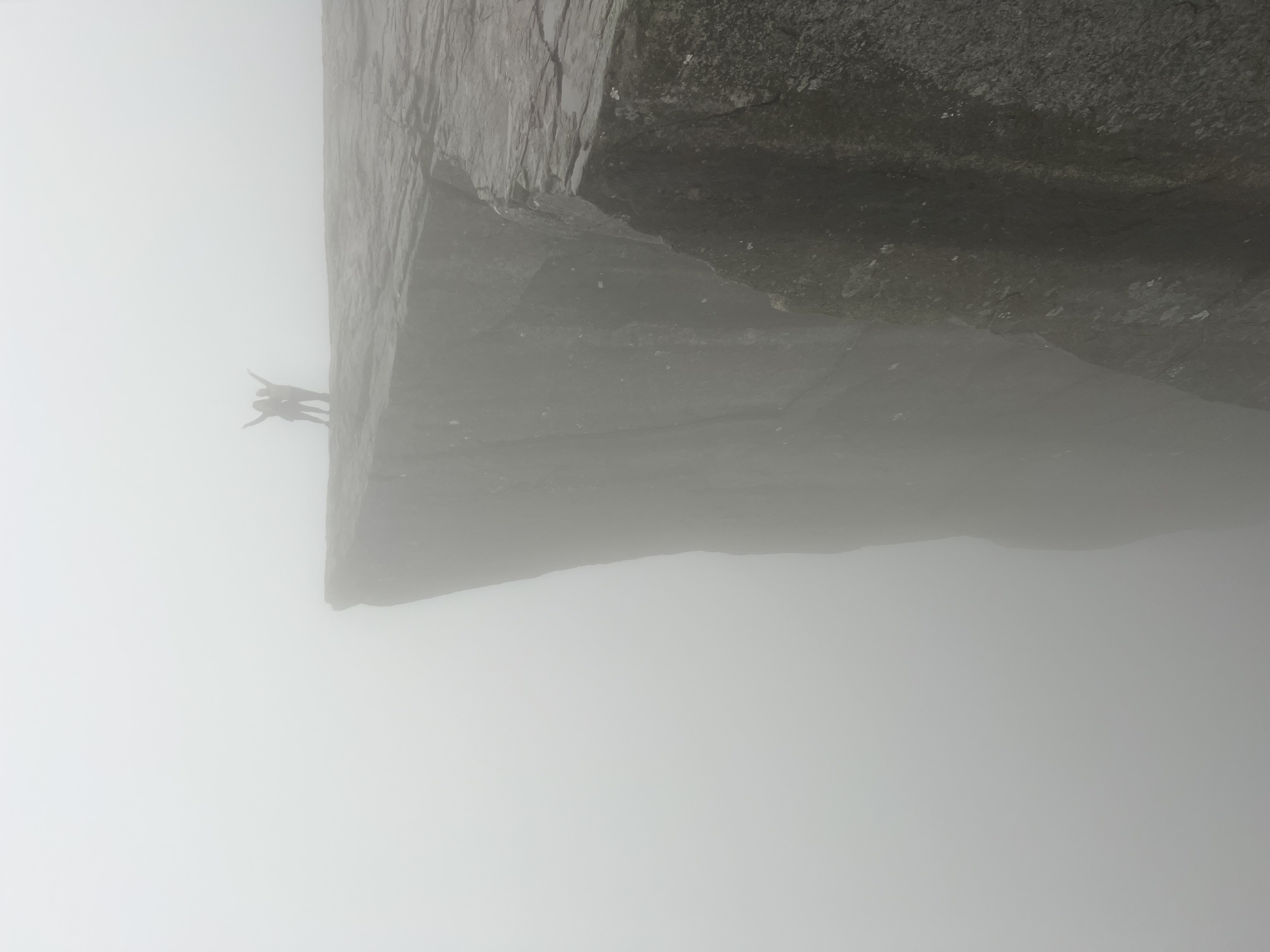 Two students pose on top of Pulpit Rock in fog