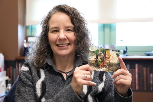 Professor Charie Faught holds a photo.