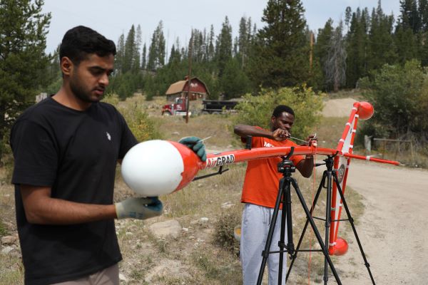 Students work with an air instrument on the ground