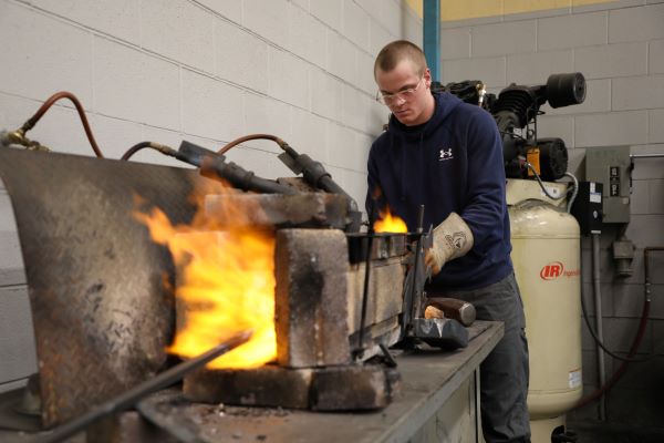 Welding student at forge