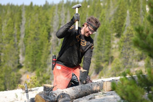 !Daniel Kelly hammers a piece of wood into the ground