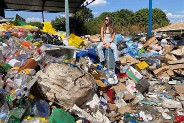 !Tara Zolnikov sits on a mountain of trash