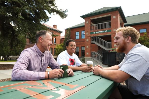 Chancellor Cook converses with students at a picnic table