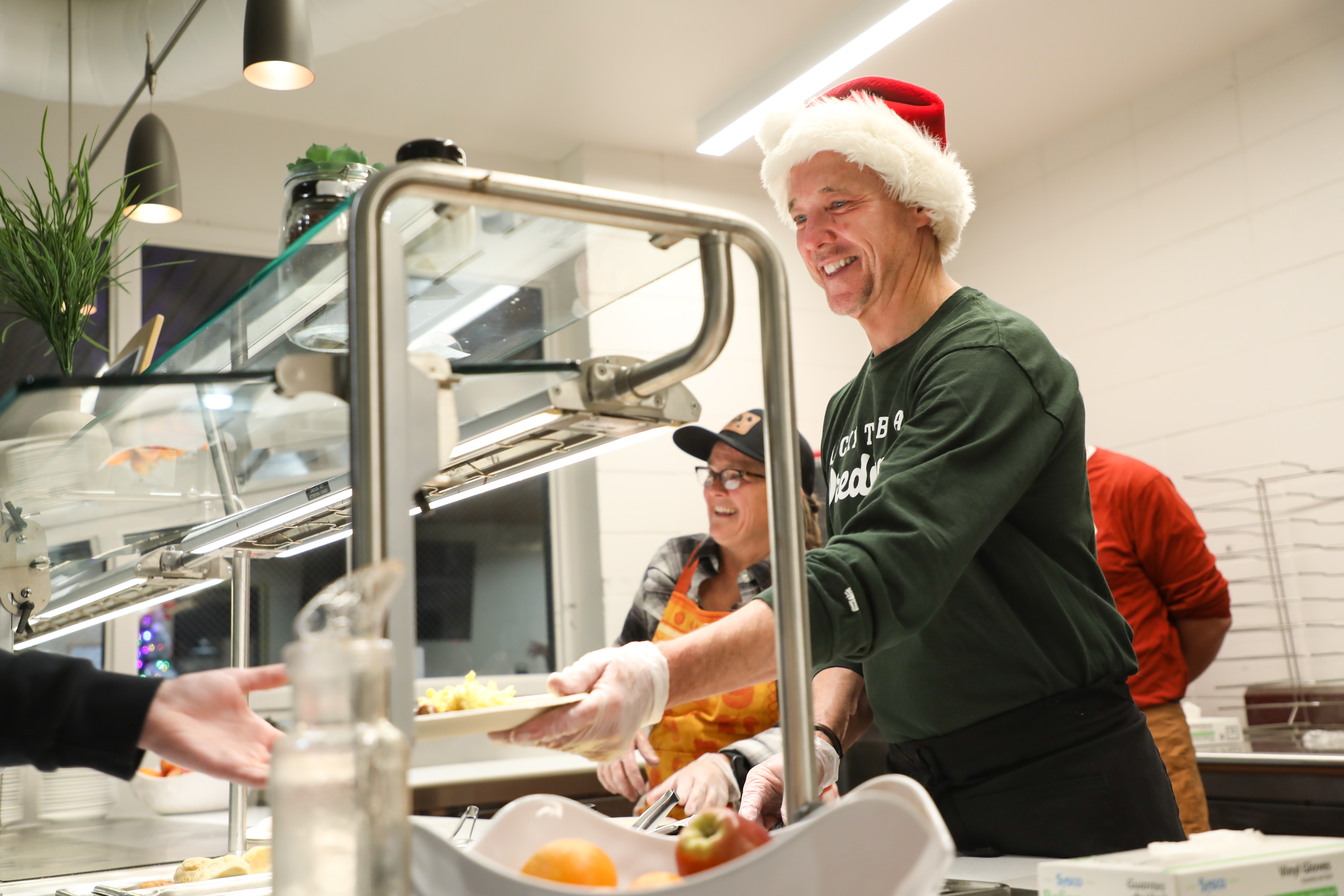 Chancellor Cook serves midnight breakfast in a Santa hat